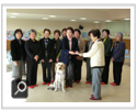 女性部・視察研修会「盲導犬協会訪問」：盲導犬と一緒に贈呈式です。